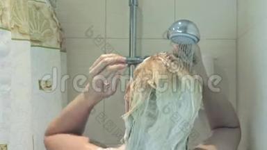 金发女人<strong>从头</strong>发上洗掉洗发水泡沫，洗头和身体护理